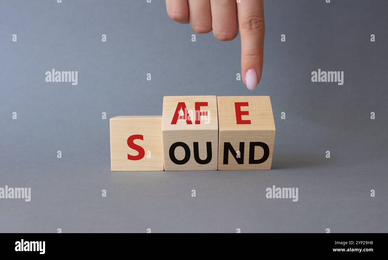 Safe and Sound symbol. Businessman hand points at cubes with words Safe ...