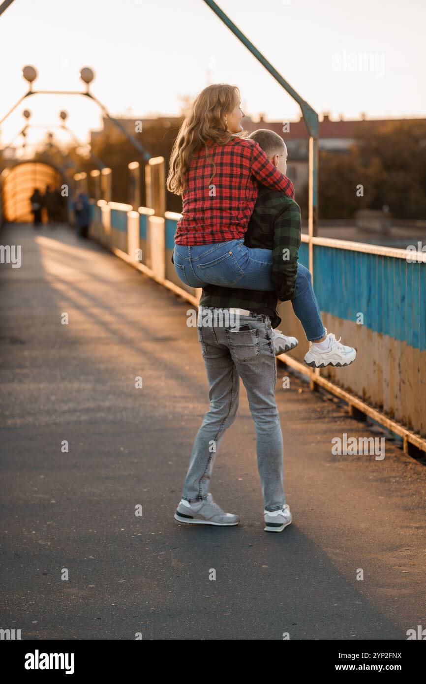 Romantic Sunset Stroll: Young Couple Embracing Joy on a Bridge Stock ...