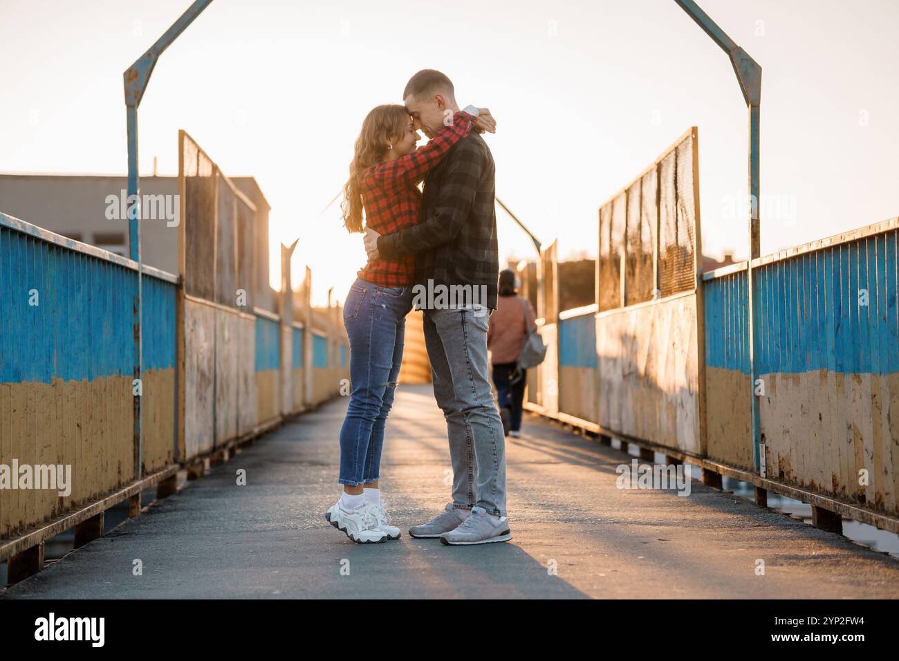 Romantic Couple Embracing on a Sunset-lit Bridge Stock Photo - Alamy