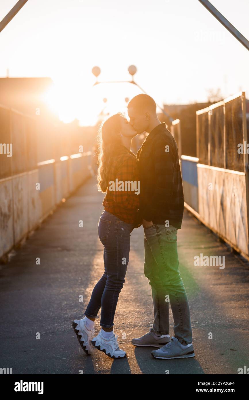 A Romantic Sunset Kiss Between a Happy Couple on an Abandoned Bridge ...