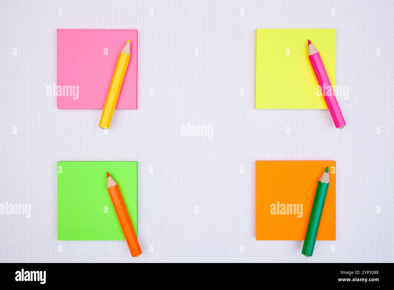 blank sticky notes with color pencils on a white canvas surface. Colorful notepads. Stock Photo