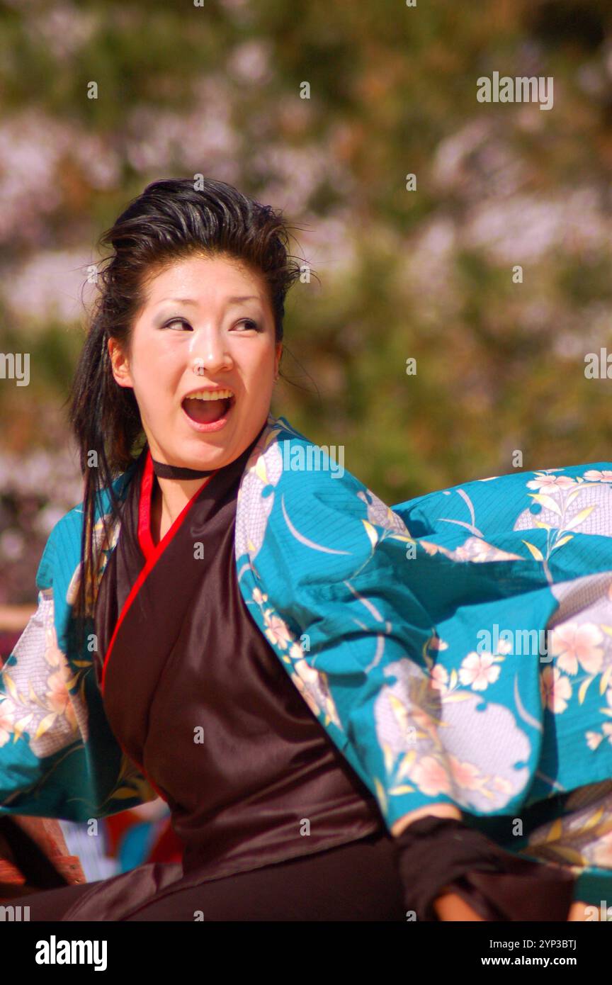 A young woman enjoys demonstrating a traditional Japanese dance at a ...