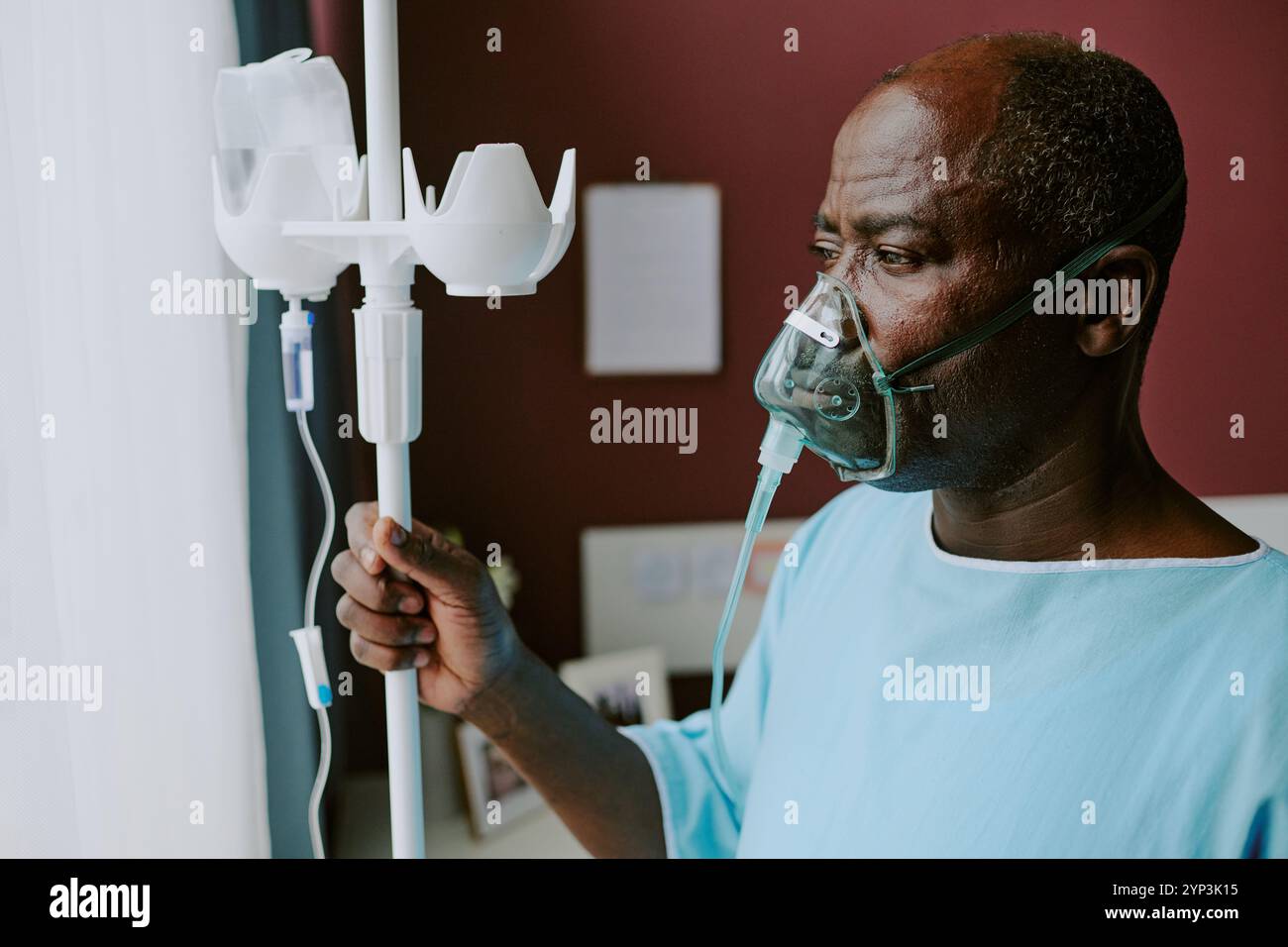 Elderly man in hospital wearing oxygen mask, standing beside ...