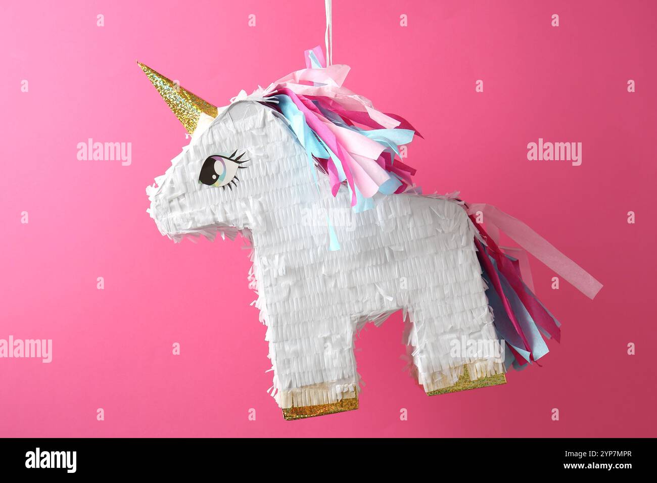 Bright pinata in shape of unicorn hanging on pink background Stock ...