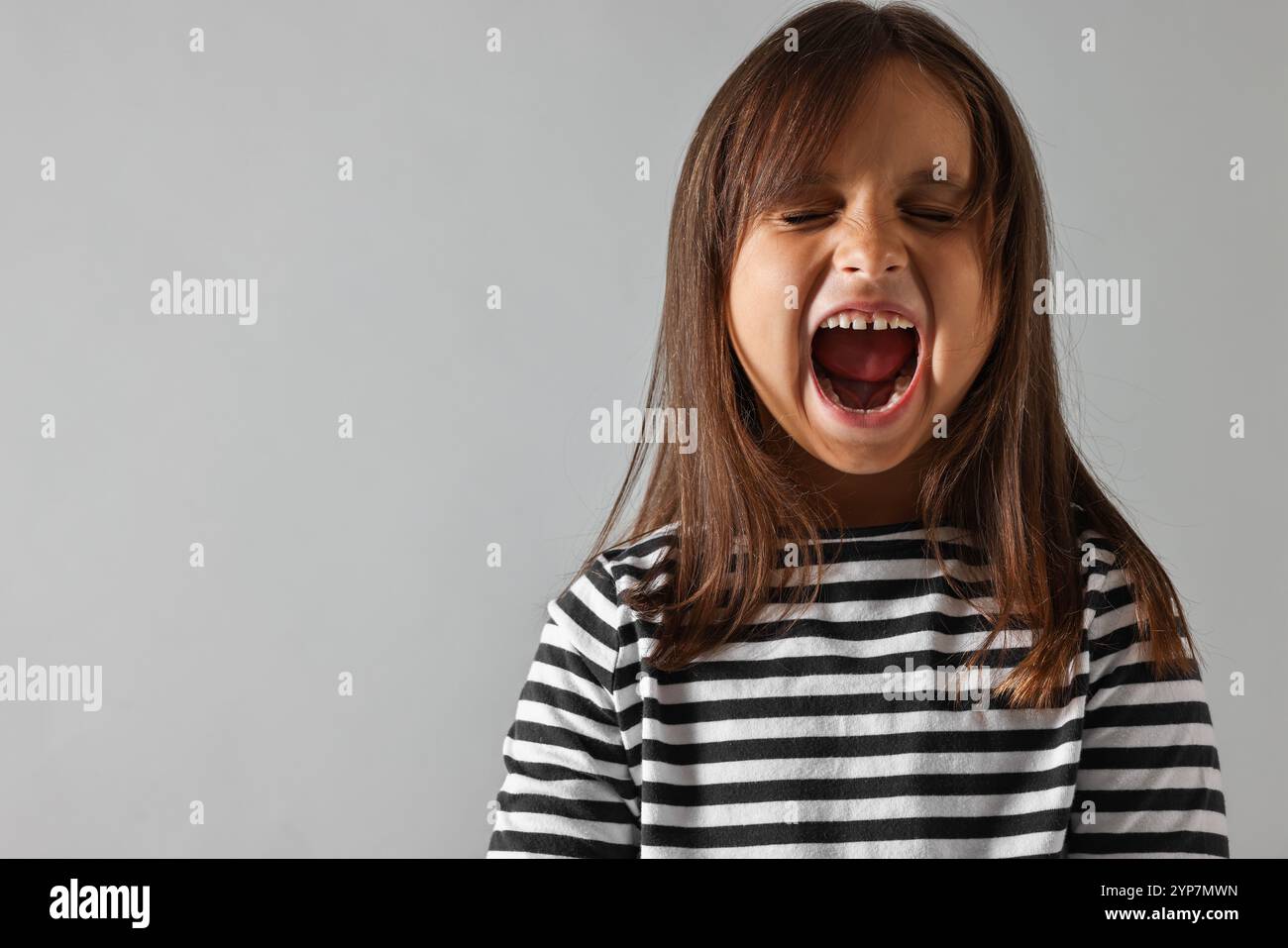 Scared little girl screaming on grey background. Space for text Stock ...