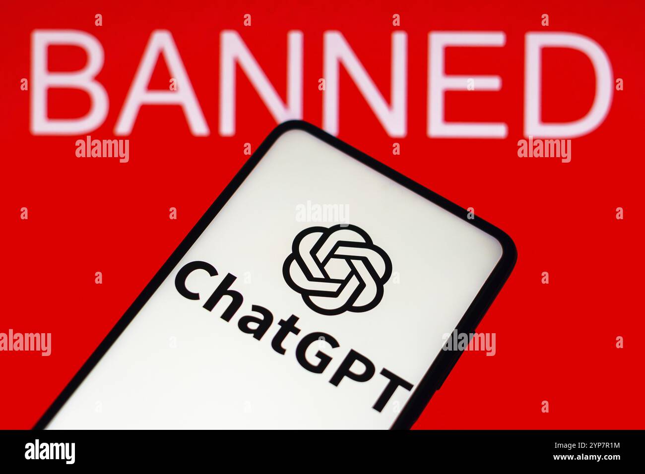 In this photo illustration, the ChatGPT logo is seen displayed on a smartphone and the banned text on the red background Stock Photo