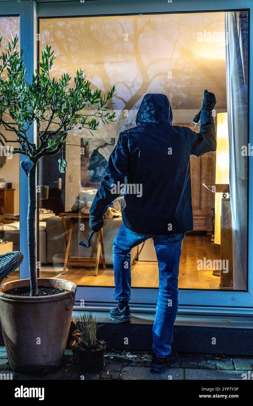 Symbolic image of a burglary, perpetrator spying on an apartment from the garden side, Stock Photo