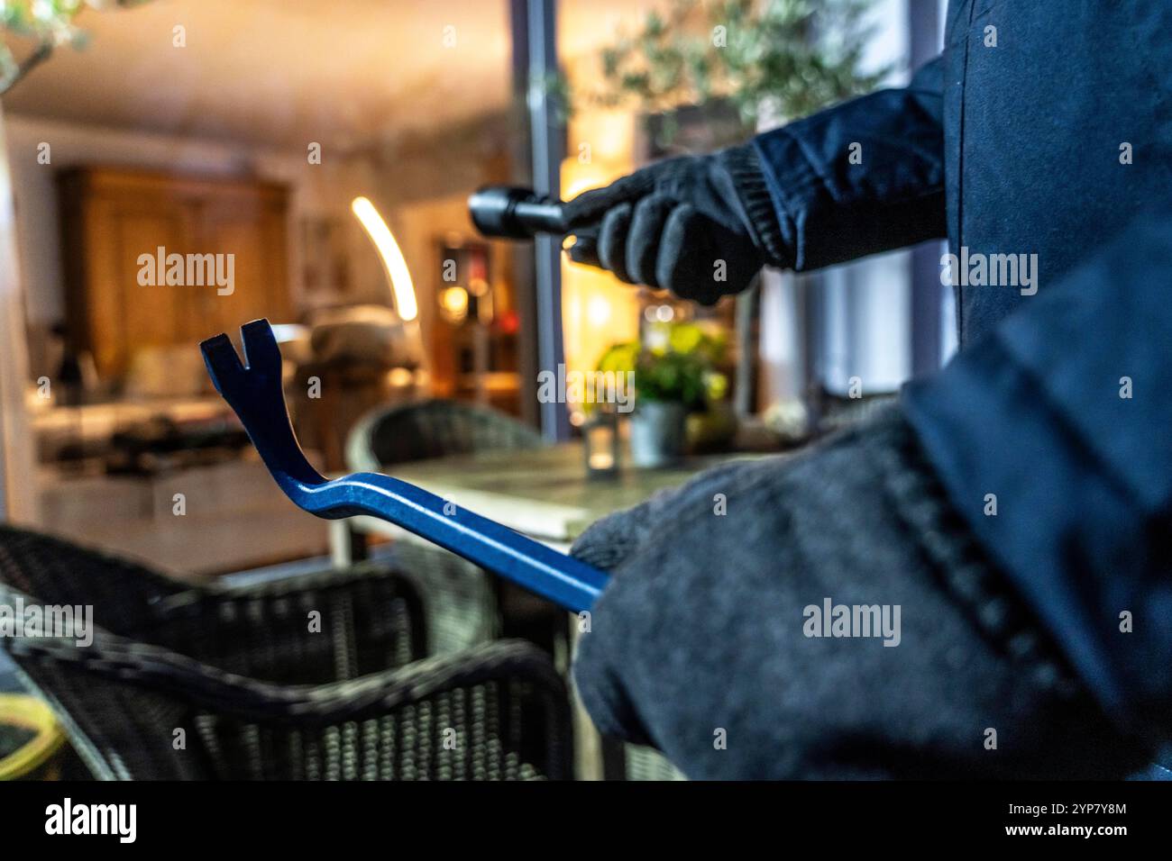 Symbolic picture of a burglary, perpetrator spying on an apartment from the garden side, Stock Photo