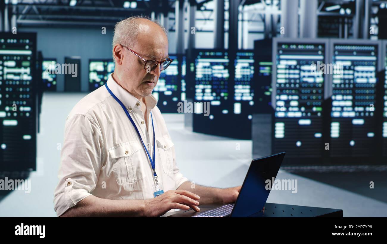 Competent inspector expertly managing data while navigating in industrial server room. Experienced system administrator ensuring optimal cybersecurity protection, optimizing systems Stock Photo