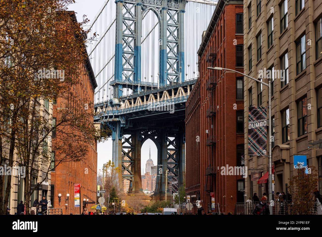 A picturesque view of the Manhattan Bridge framed by the iconic red ...
