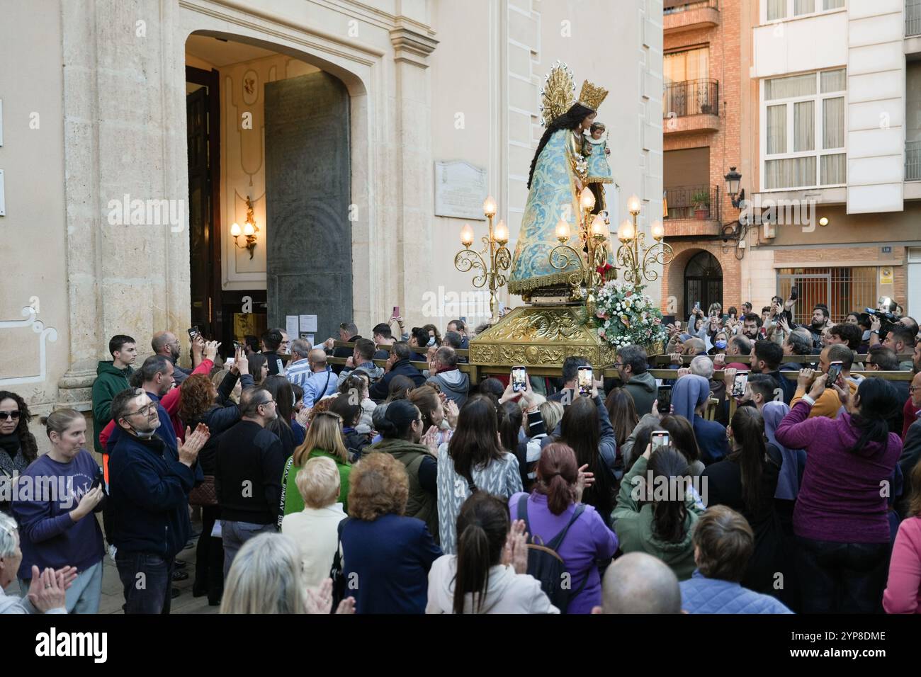 Paiporta, Spain - November 28, 2024. The Virgen de Los Desamparados visits Parroquias San Ramón and San Jorge in Paiporta in occasion of DANA's Eve (vísperas de la DANA).Many believers gathered to pay tribute to the Virgin and honour the memory of dead and missing people. Observant and devoted people touch the Virgin statue in commotion with the photos of their lost beloved ones. Credit: Roberto Arosio/Alamy Live News Stock Photo