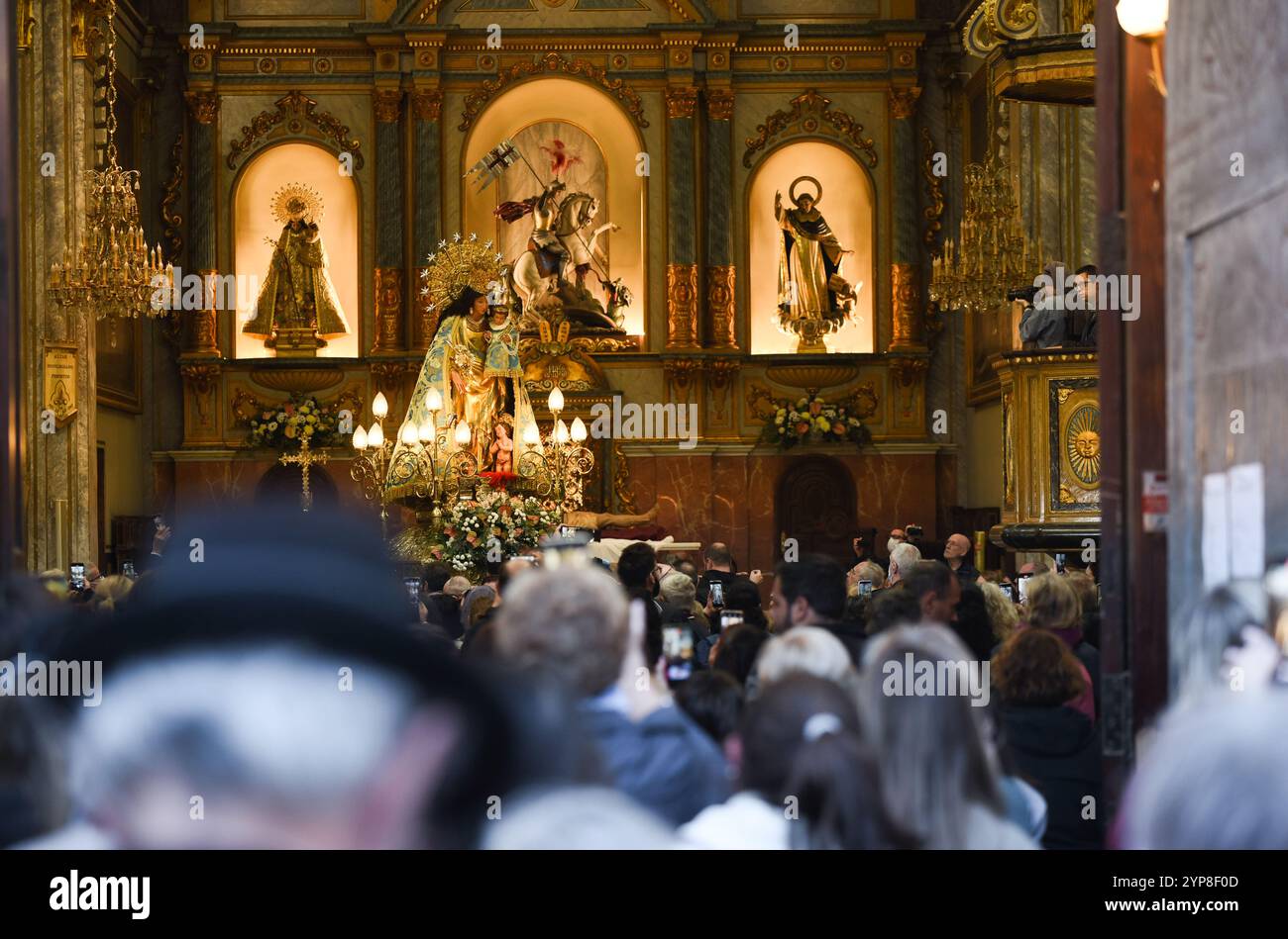 Paiporta, Spain - November 28, 2024. The Virgen de Los Desamparados visits Parroquias San Ramón and San Jorge in Paiporta in occasion of DANA's Eve (vísperas de la DANA).Many believers gathered to pay tribute to the Virgin and honour the memory of dead and missing people. Observant and devoted people touch the Virgin statue in commotion with the photos of their lost beloved ones. Credit: Roberto Arosio/Alamy Live News Stock Photo