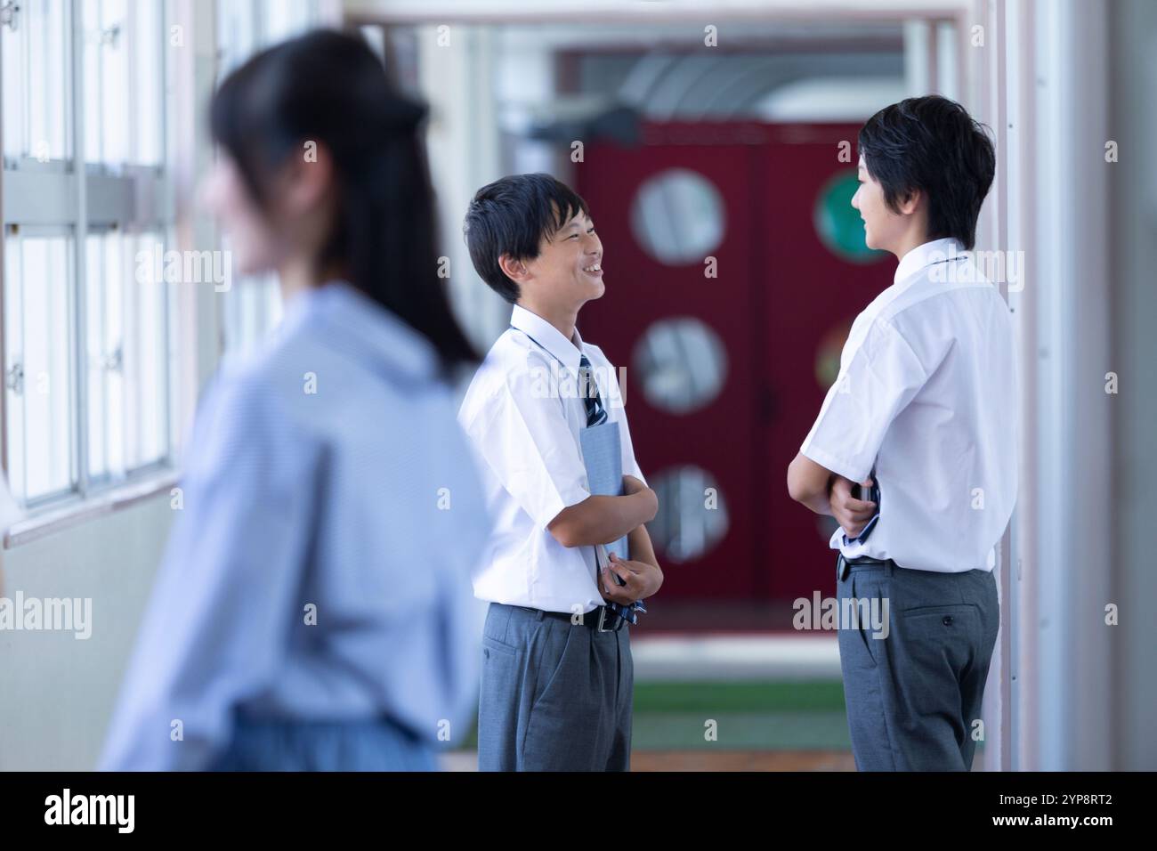 Junior high school students chatting in the corridor Stock Photo - Alamy
