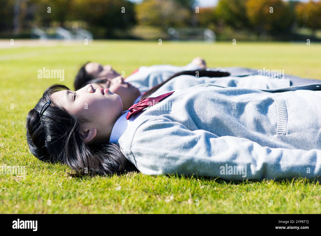 High school student lying on lawn Stock Photo