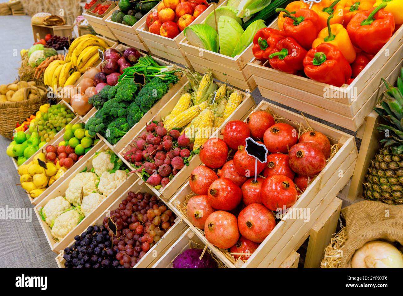 Fresh colorful fruits, vegetables are arranged neatly in wooden crates ...