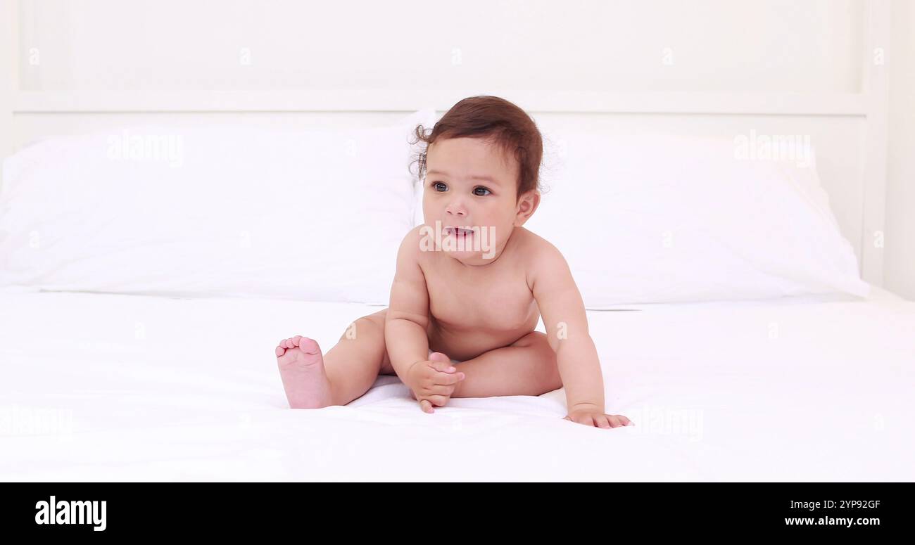 Baby sitting on bed hi-res stock photography and images - Alamy