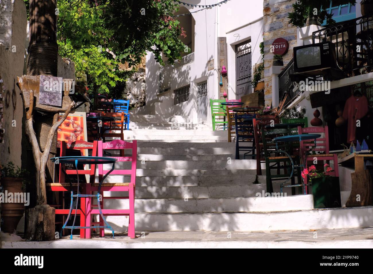 Naxos: Restaurant, colourful chairs and steps up to Eglise de la Vierge de Filoti in Filoti, Naxos, Cyclades island, Greece Stock Photo