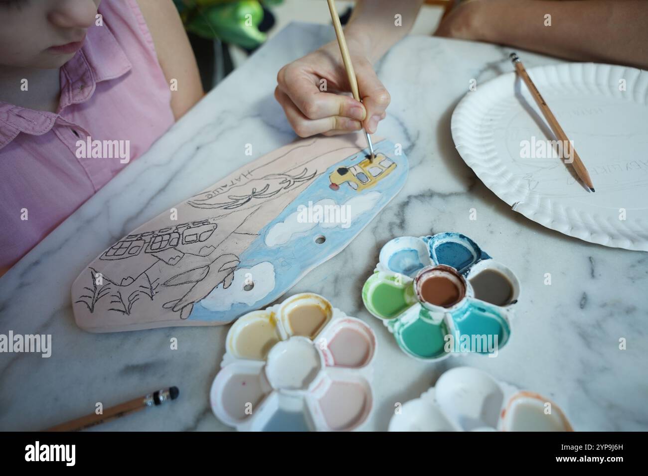 A young mother and her daughter enjoy a creative art session at home ...
