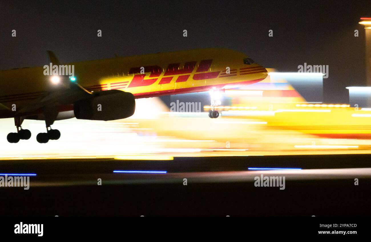 Leipzig, Germany. 26th Nov, 2024. A DHL plane lands at the DHL hub at Leipzig/Halle Airport late in the evening. With the freight center of the Post subsidiary DHL, the airport is one of the world's most important centers for air freight. Credit: Hendrik Schmidt/dpa/Alamy Live News Stock Photo