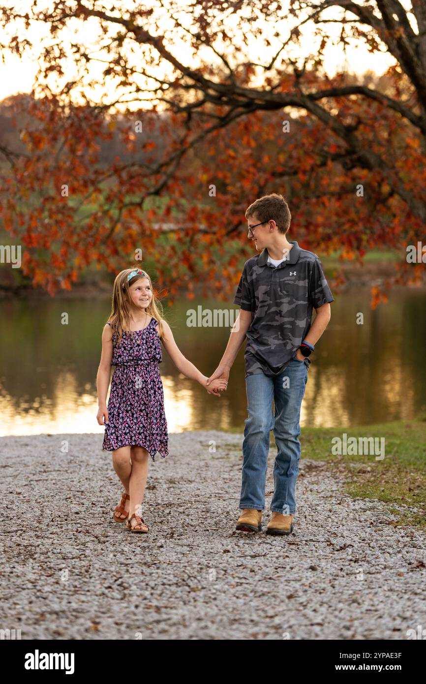Brother and Sister walking together holding hands Stock Photo - Alamy