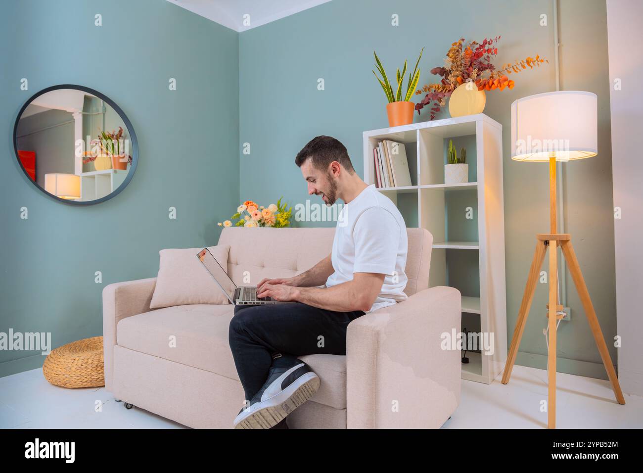 Man working on laptop in cozy living room Stock Photo