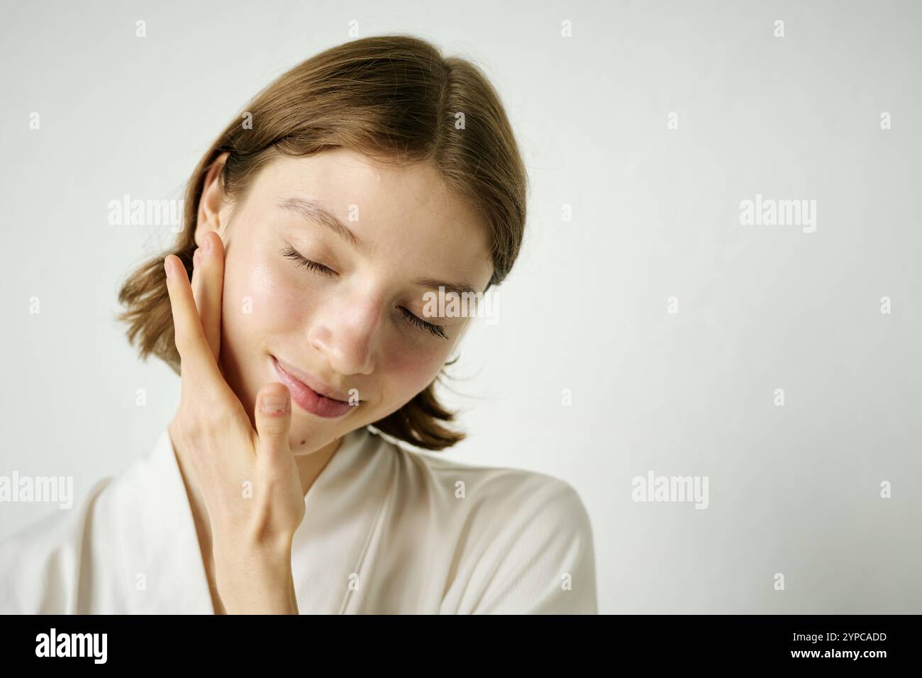 Medium close up of young Caucasian woman testing new face serum, she enjoying process and relaxing Stock Photo