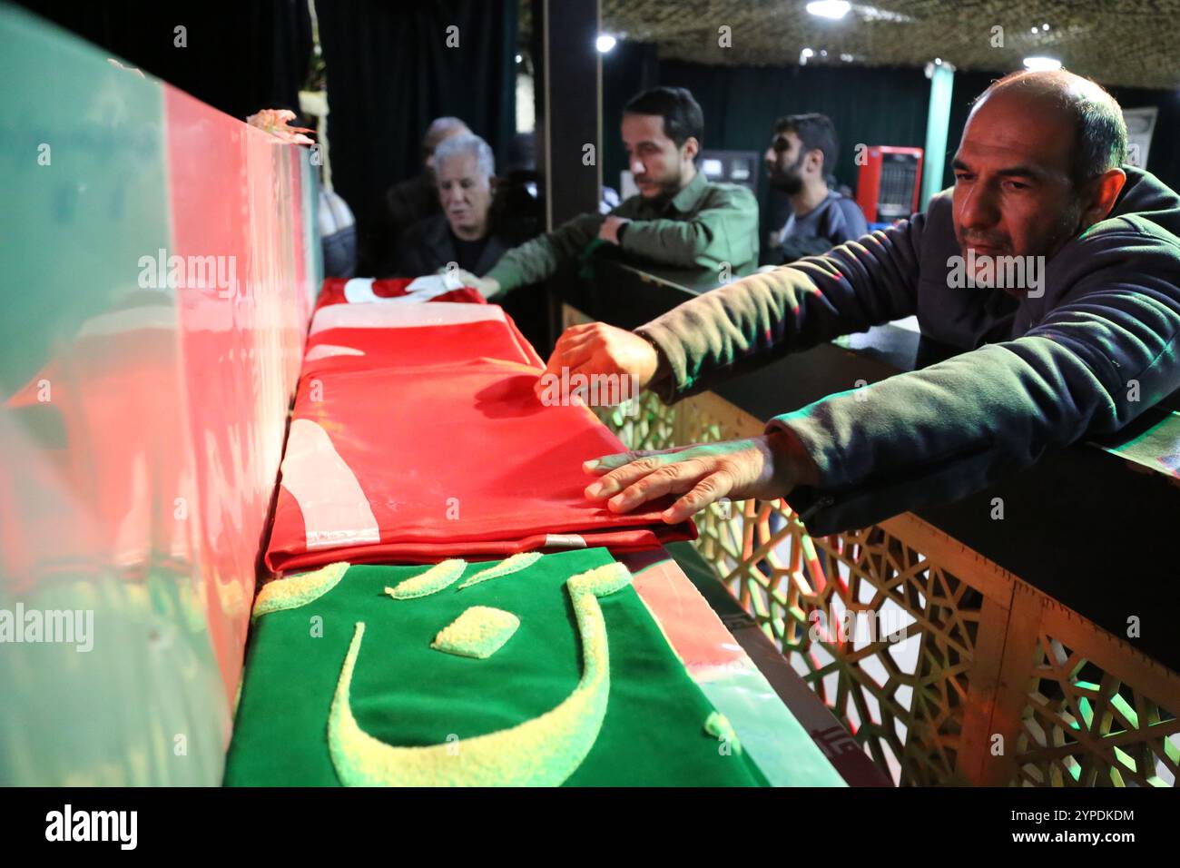 Tehran, Iran. 29th Nov, 2024. Iranian men touch the coffins of anonymous martyrs during the funeral ceremony of Brigadier General Porhashmi, a senior officer of the Islamic Revolutionary Guard Corps (IRGC) Quds Force, who was killed in Aleppo, Syria. The IRGC Quds Force is a unit of Iran's Revolutionary Guard that conducts military, intelligence, and support operations abroad to advance Iran's regional influence. (Credit Image: © Rouzbeh Fouladi/ZUMA Press Wire) EDITORIAL USAGE ONLY! Not for Commercial USAGE! Credit: ZUMA Press, Inc./Alamy Live News Stock Photo