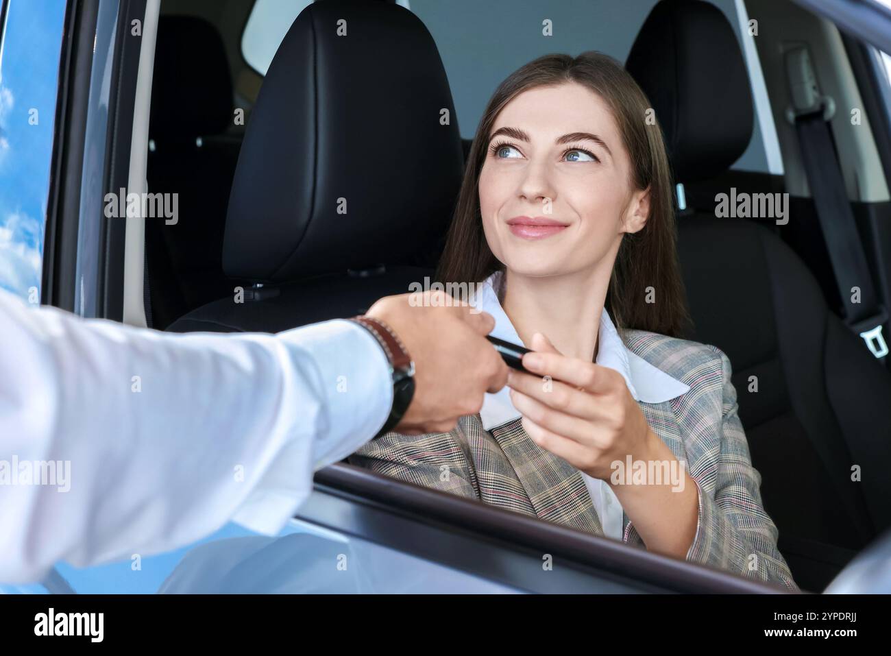 Salesman giving key to client inside new car in salon Stock Photo - Alamy