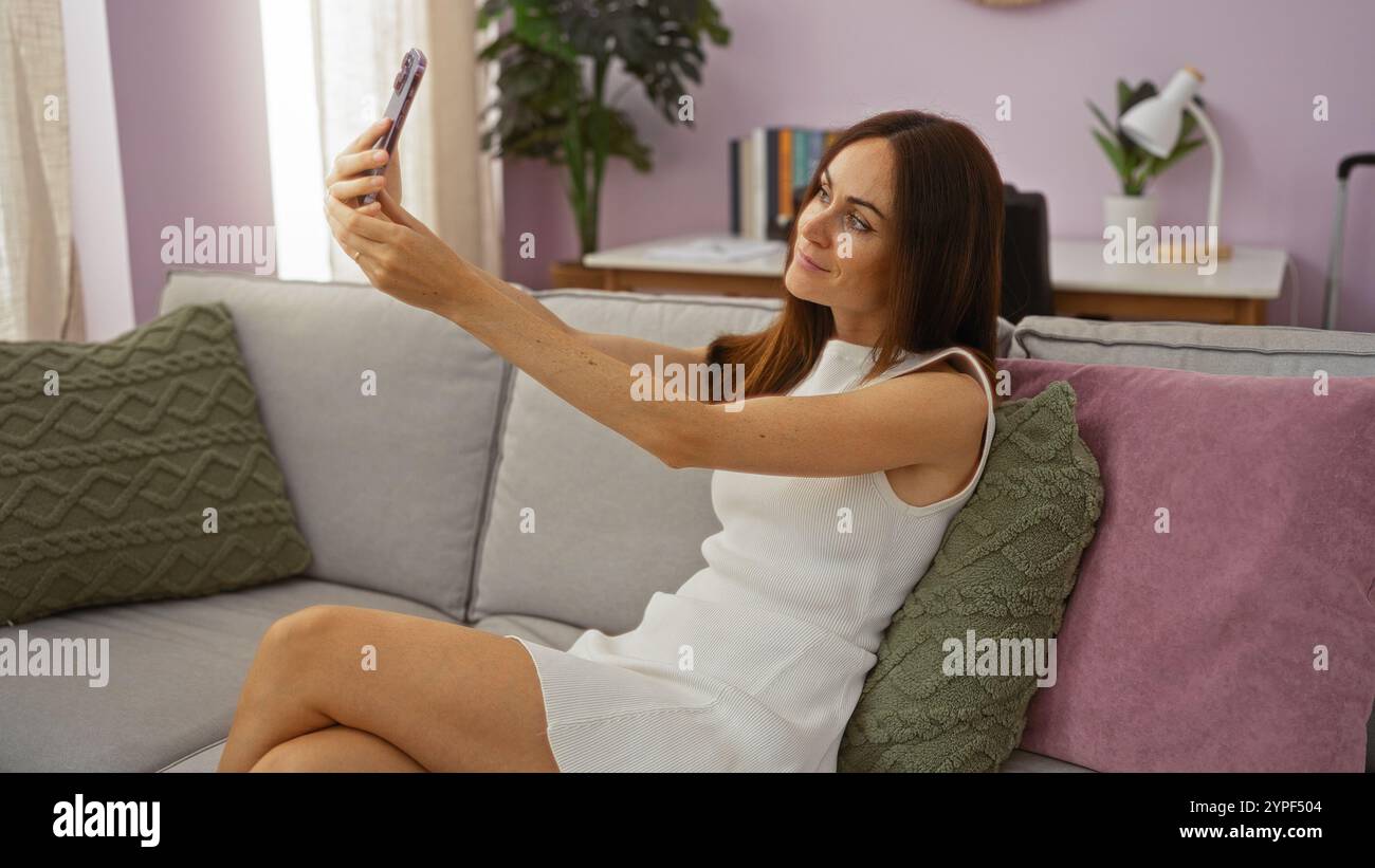 Brunette woman taking selfie in a cozy living room interior with purple ...