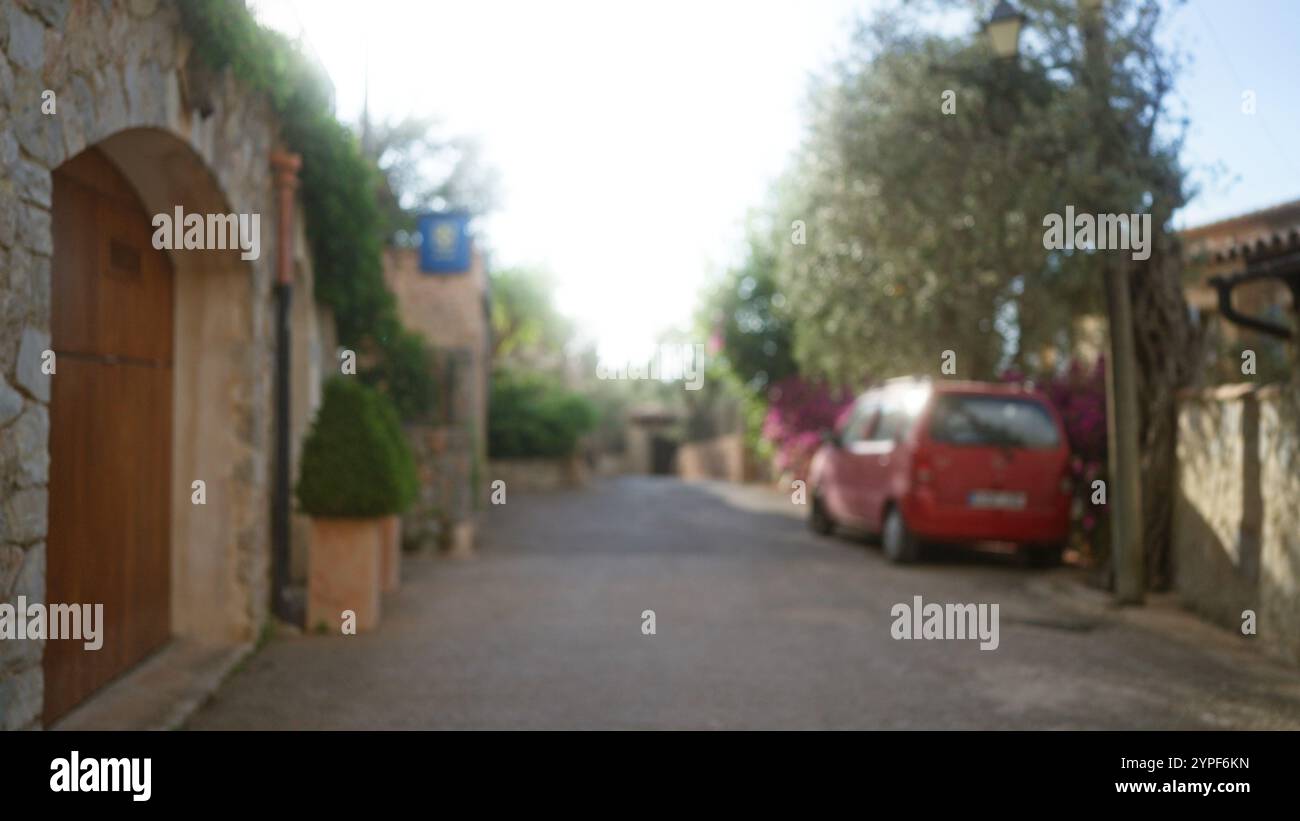 Blurred street scene in mallorca, featuring a defocused red car and ...