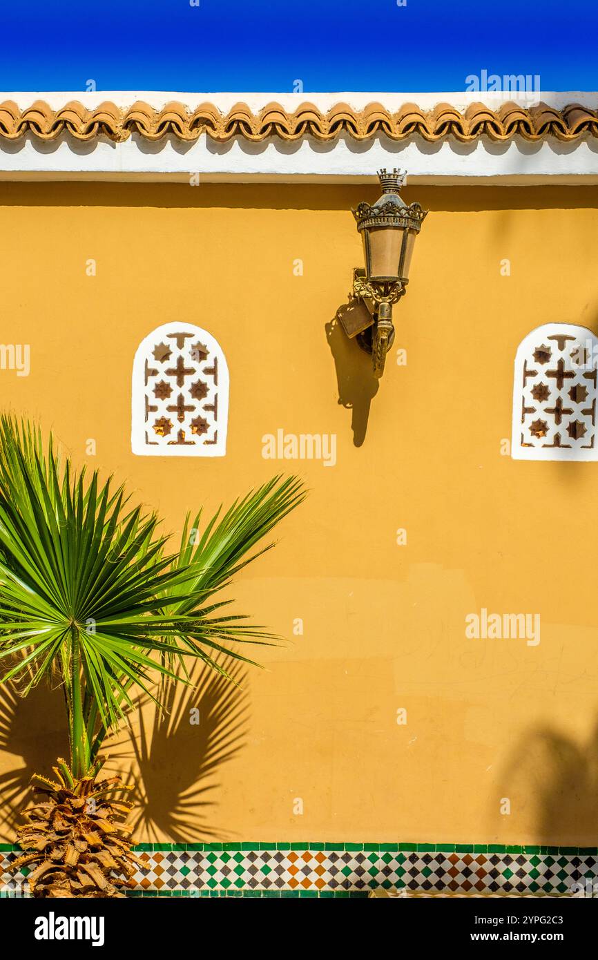 A wall in Taroudant with typical decorative Moroccan features including arched windows Stock Photo