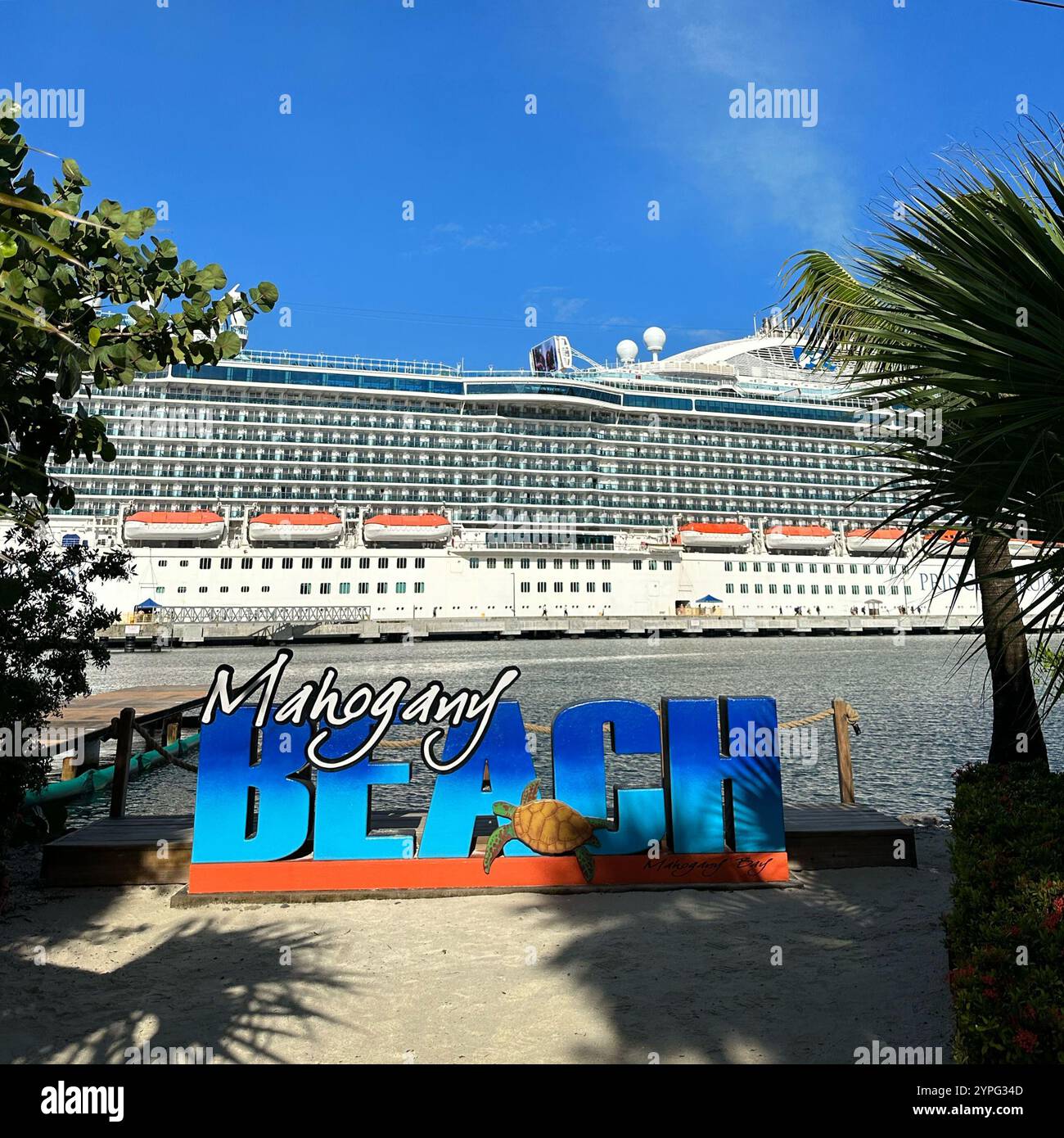 Regal Princes cruise ship and Mahogany Beach sign, Mahogany Bay, Roatan, Bay Islands, Honduras, Central America - Smartphone Captured Stock Image