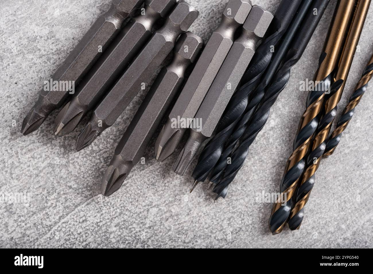 Set of different drill bits on grey stone background. Construction tools Stock Photo