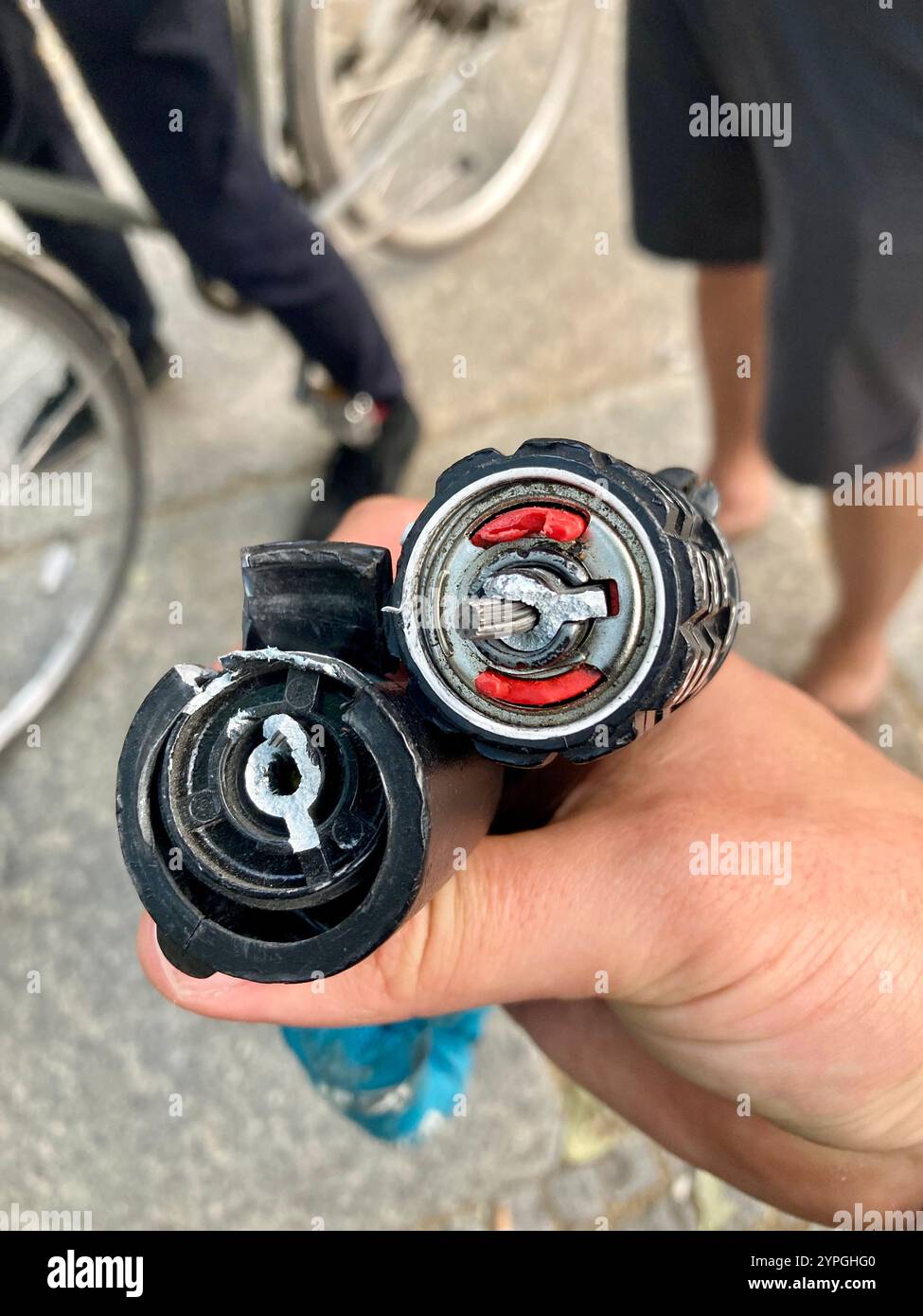 A broken bike combination lock by the German manufacturer Abus in a man's hand - Smartphone Captured Stock Image