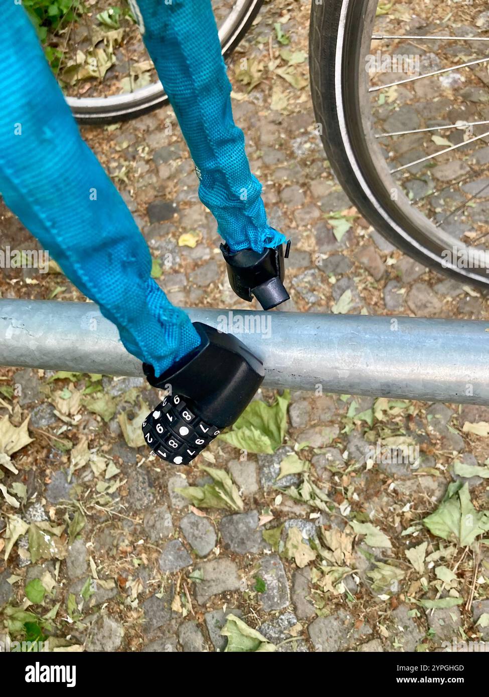 A broken bike combination lock by the German manufacturer Abus hanging on a cycle rack - Smartphone Captured Stock Image