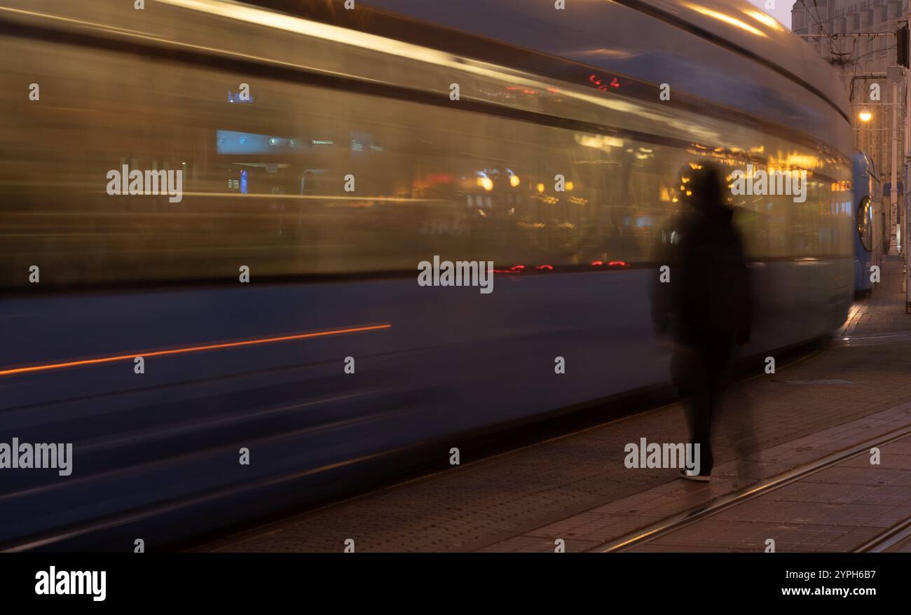 Fast electric tram passing on a city street in europe Stock Photo - Alamy
