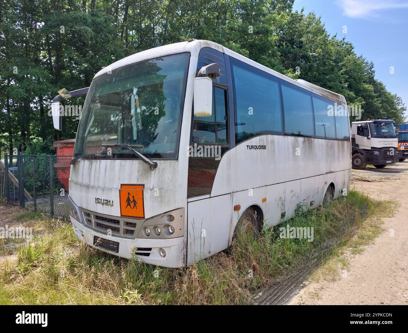 old dilapidated out of use isuzu turquoise school bus sitting on patch of industrial waste ground zala county hungary Stock Photo