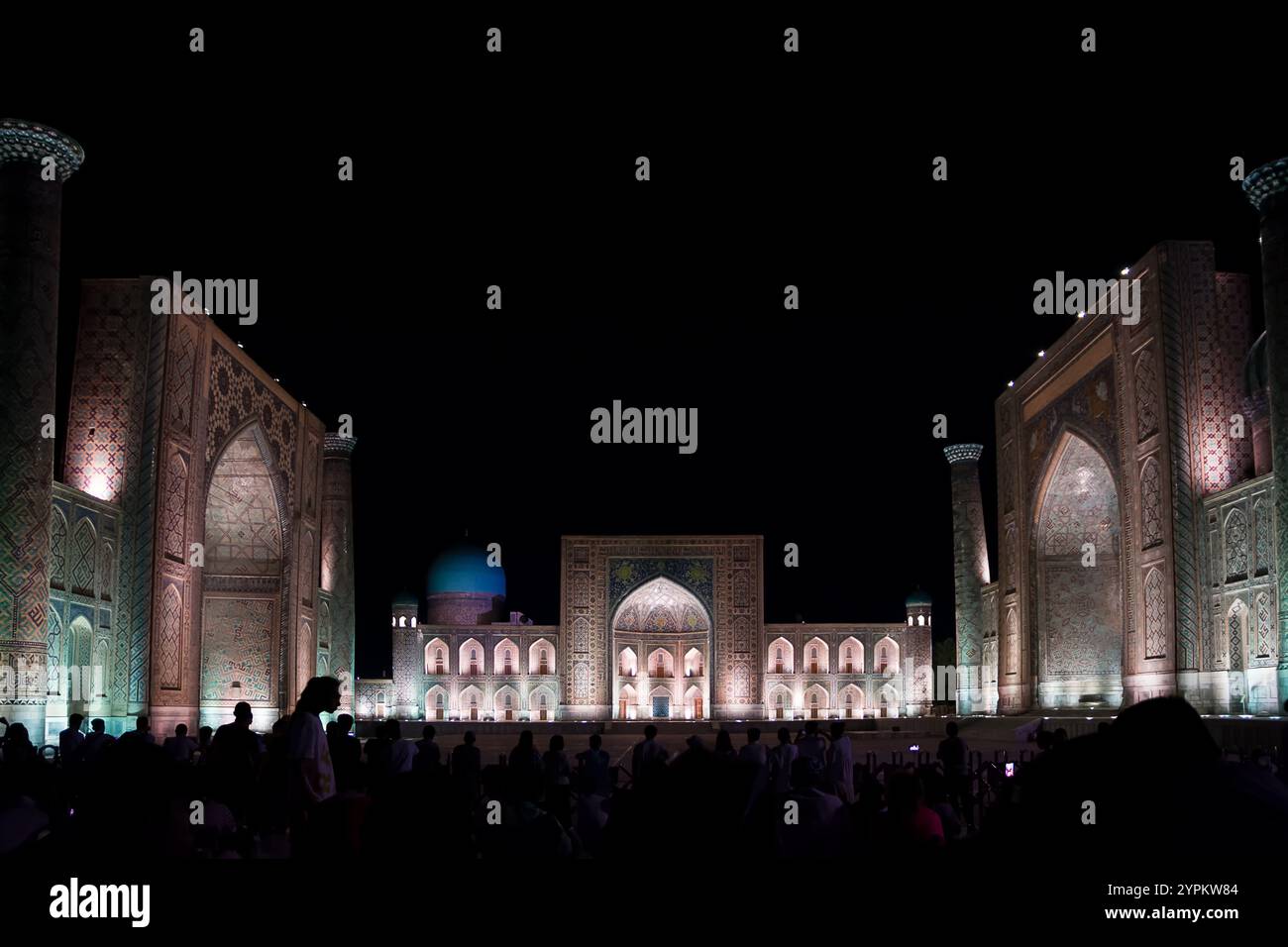 Samarkand, Uzbekistan - 06 July 2024: Registan at night illuminated by lights and tourists waiting for the show Stock Photo