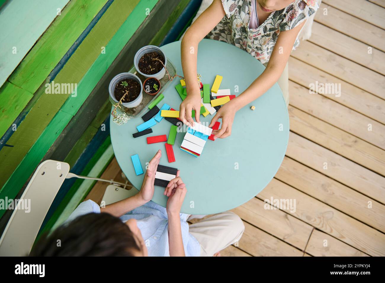 Two children are engaged in building with colorful blocks on a round ...
