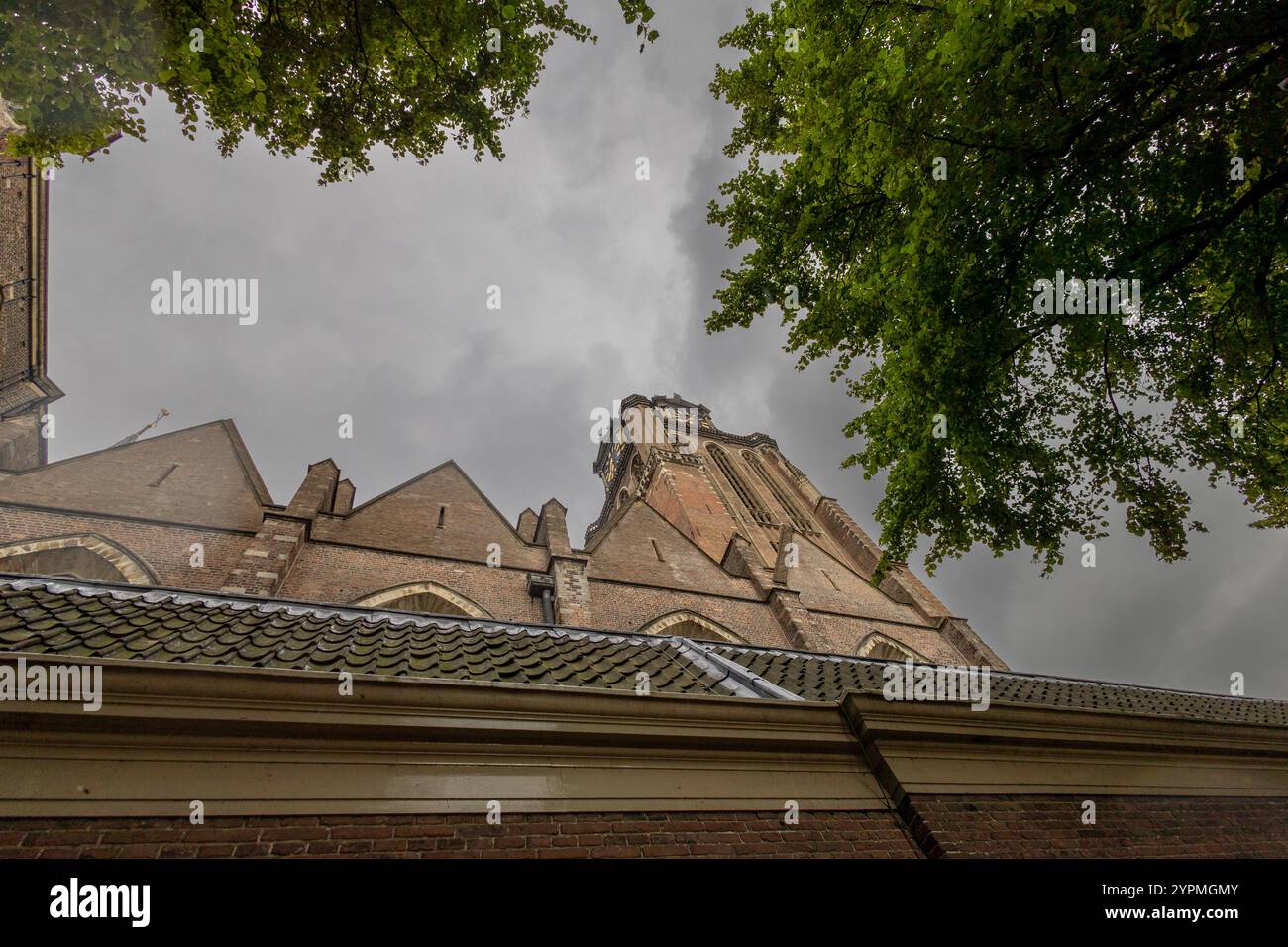 A majestic Gothic church under a dramatic cloudy sky. The intricate ...