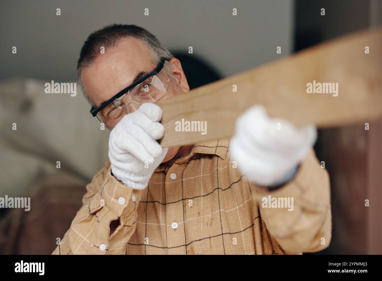 Senior Handyman Working In Workshop Stock Photo