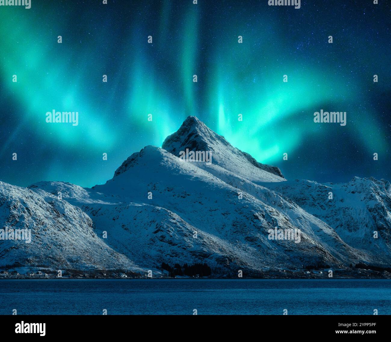 Northern lights over the snowy mountains at night in Lofoten Stock ...