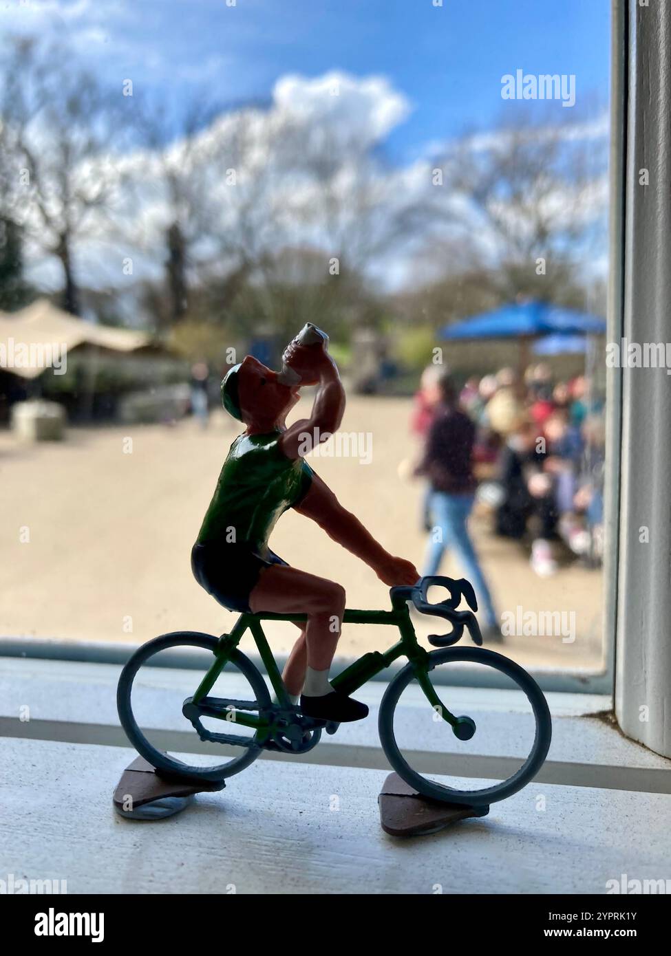 The silhouette of a figurine of a cyclist on a road racing bike drinking from his bottle in a window of a cafe in London, England - Smartphone Captured Stock Image
