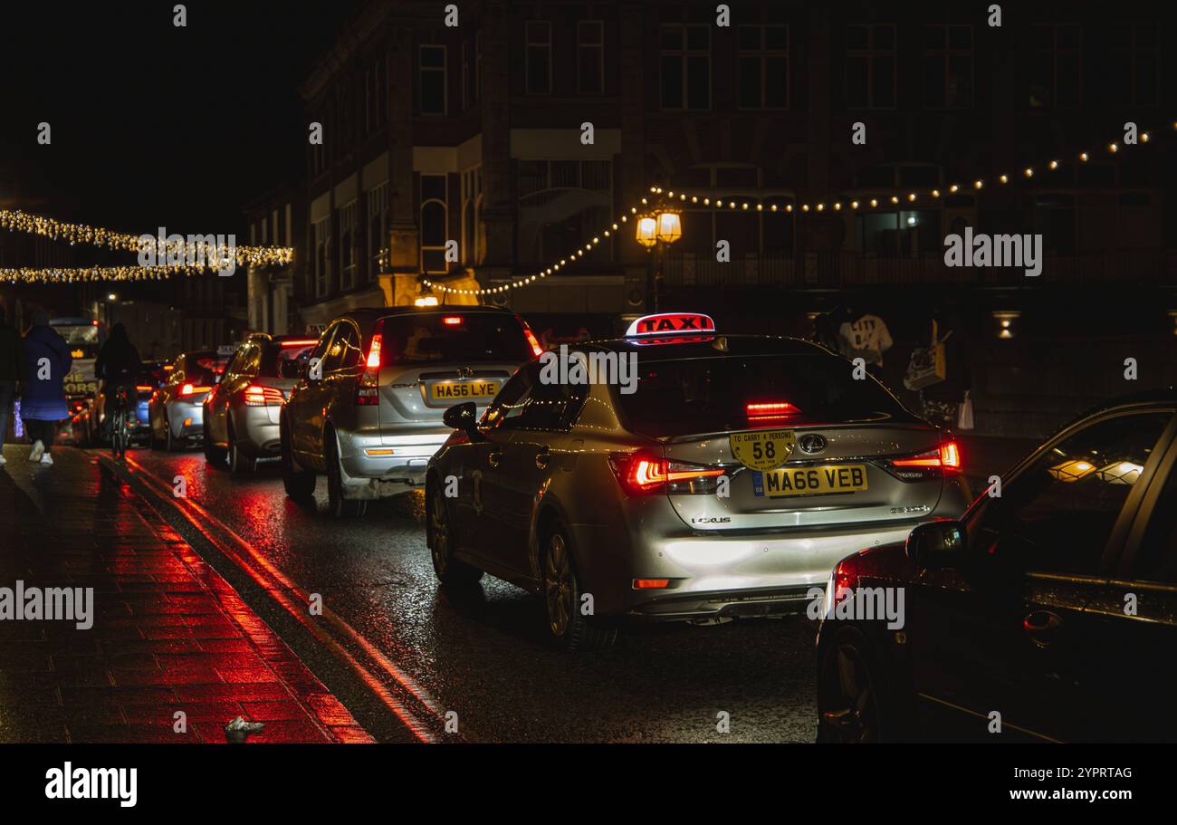 Line of cars going over Ouse bridge York on a wet night with festive string lights illuminating the scene creating a cozy atmosphere Nov 2024 Stock Photo
