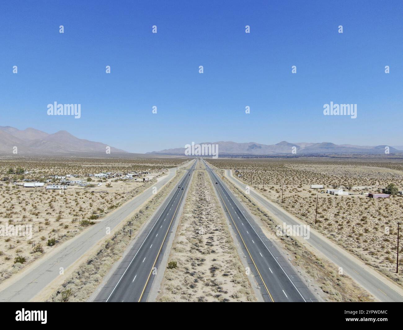 Aerial view of road in the middle of the desert under blue sky in ...