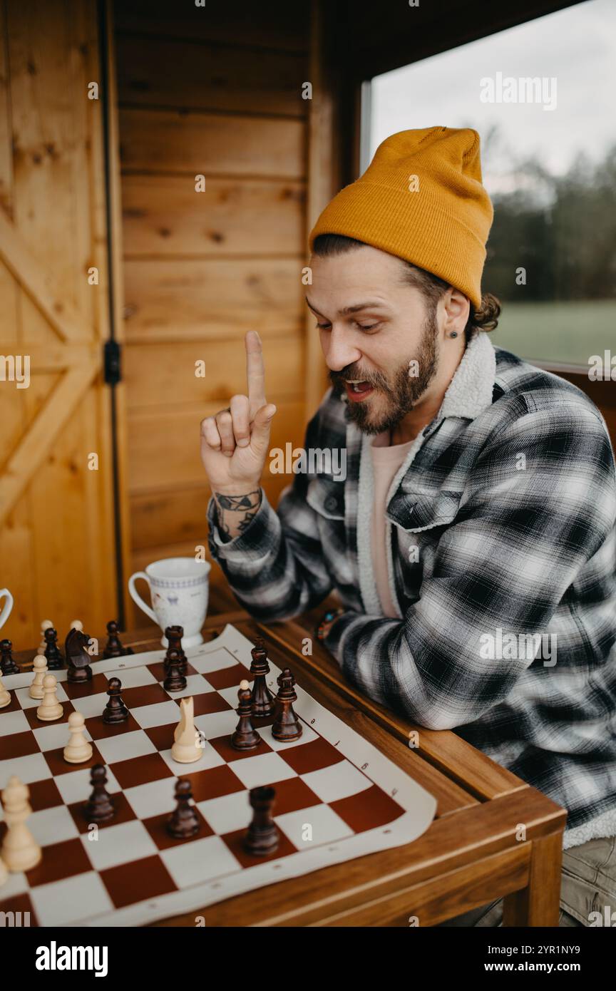 Handsome young man plays chess and came up with solution outdoors. Stock Photo