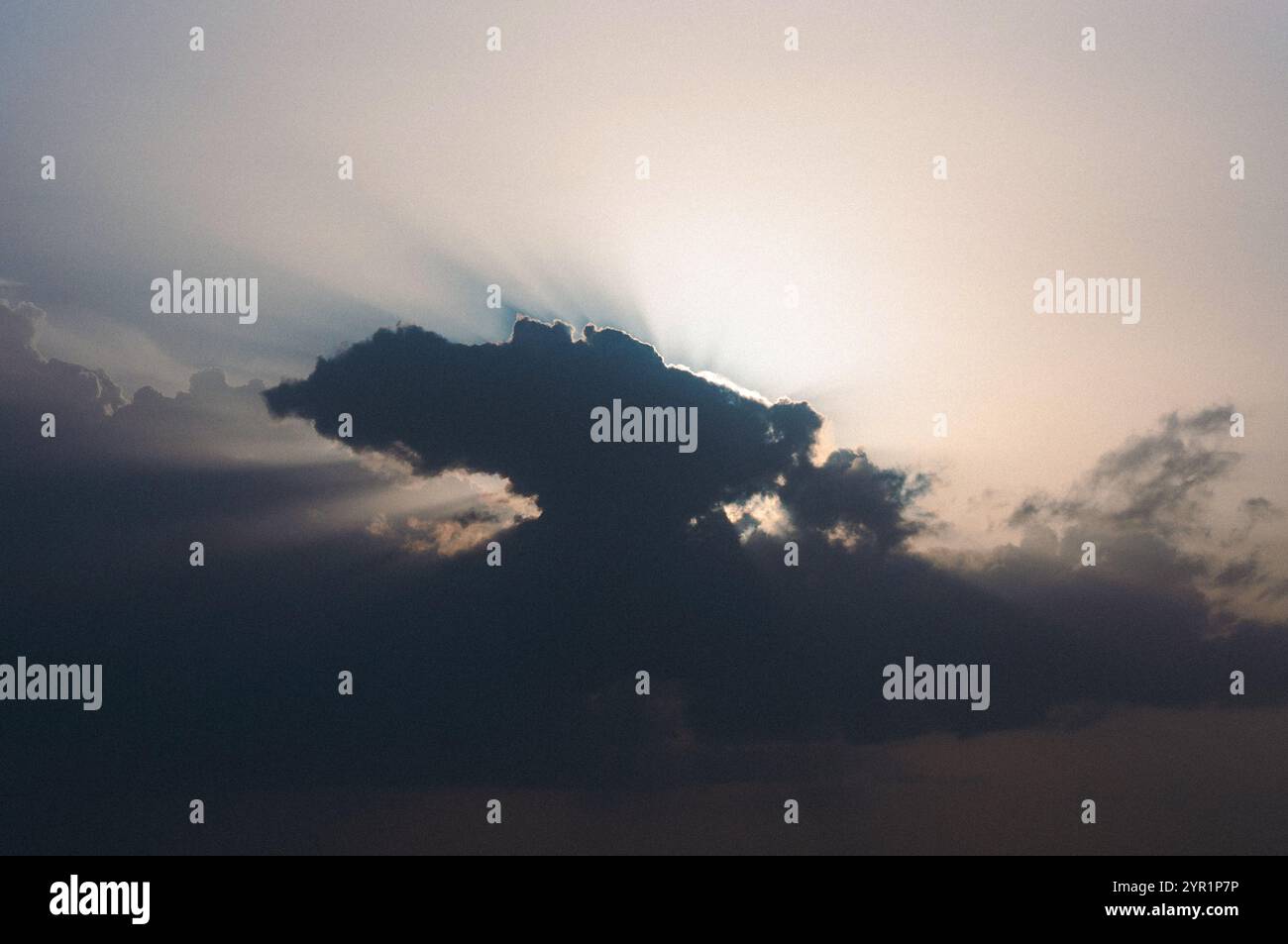 Sunset sky, sun rays from behind the clouds Stock Photo