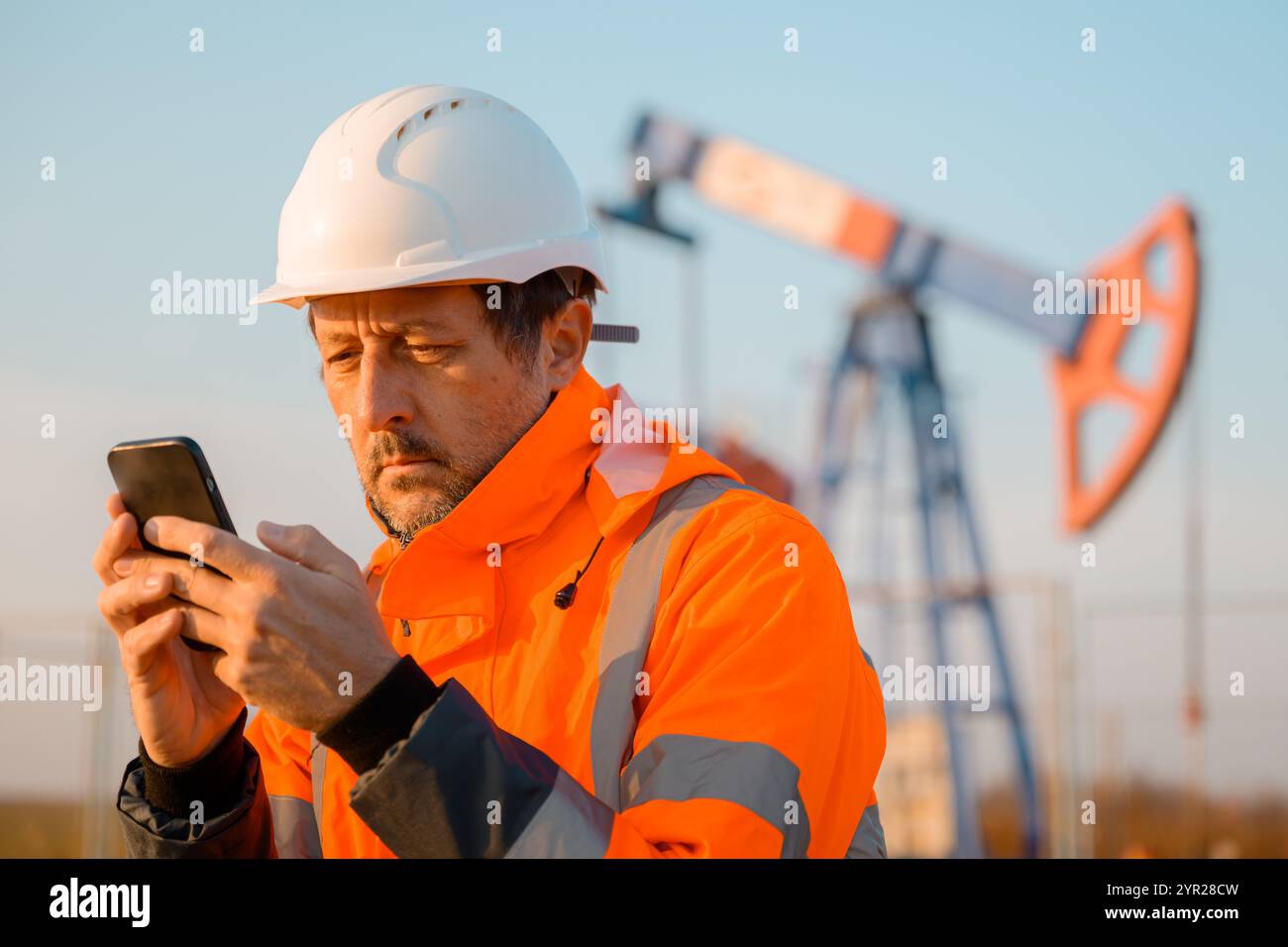 Drilling rig engineer using mobile phone while supervising the process ...