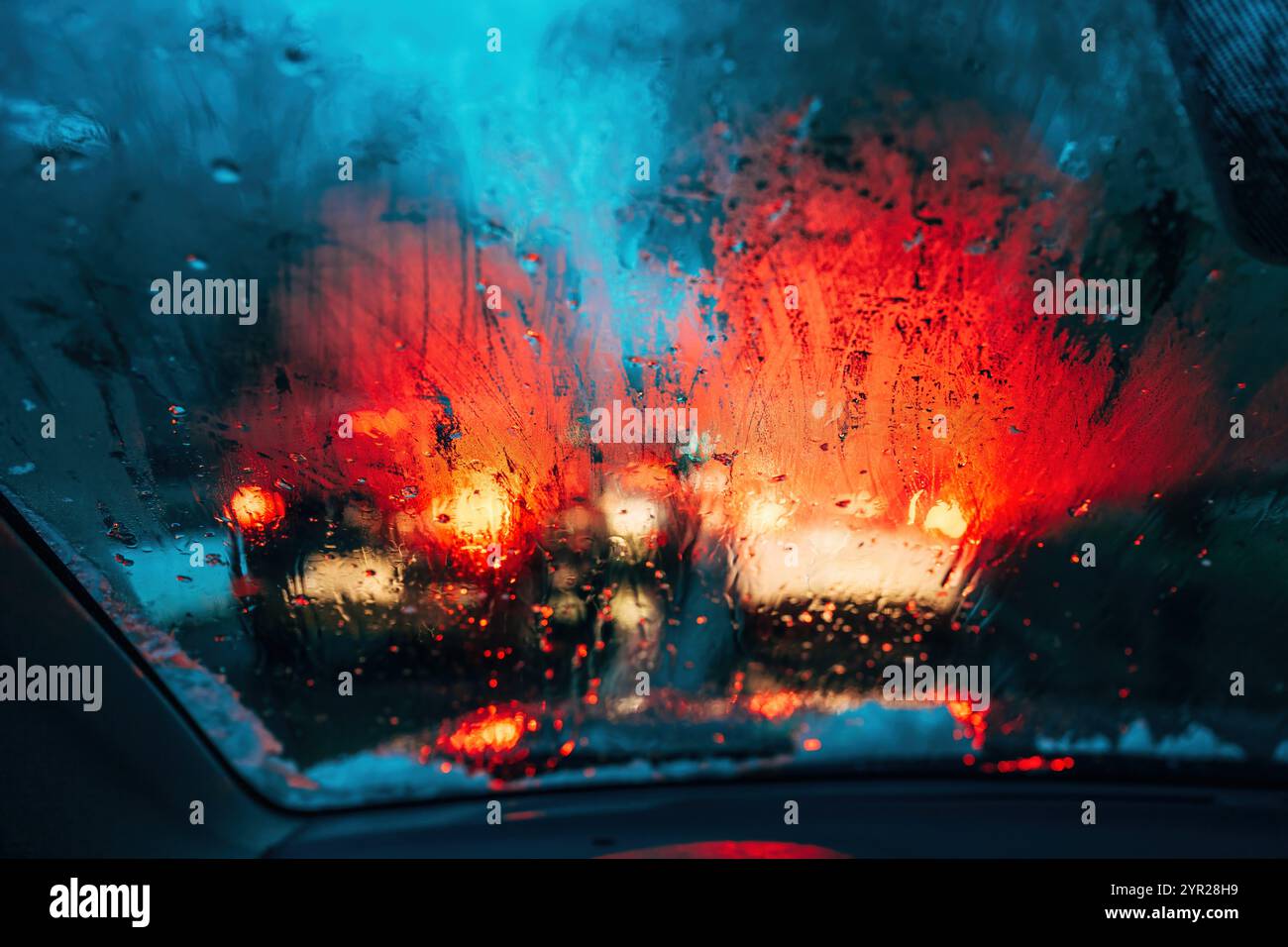 Traffic lights on rainy night, bokeh background with selective focus Stock Photo