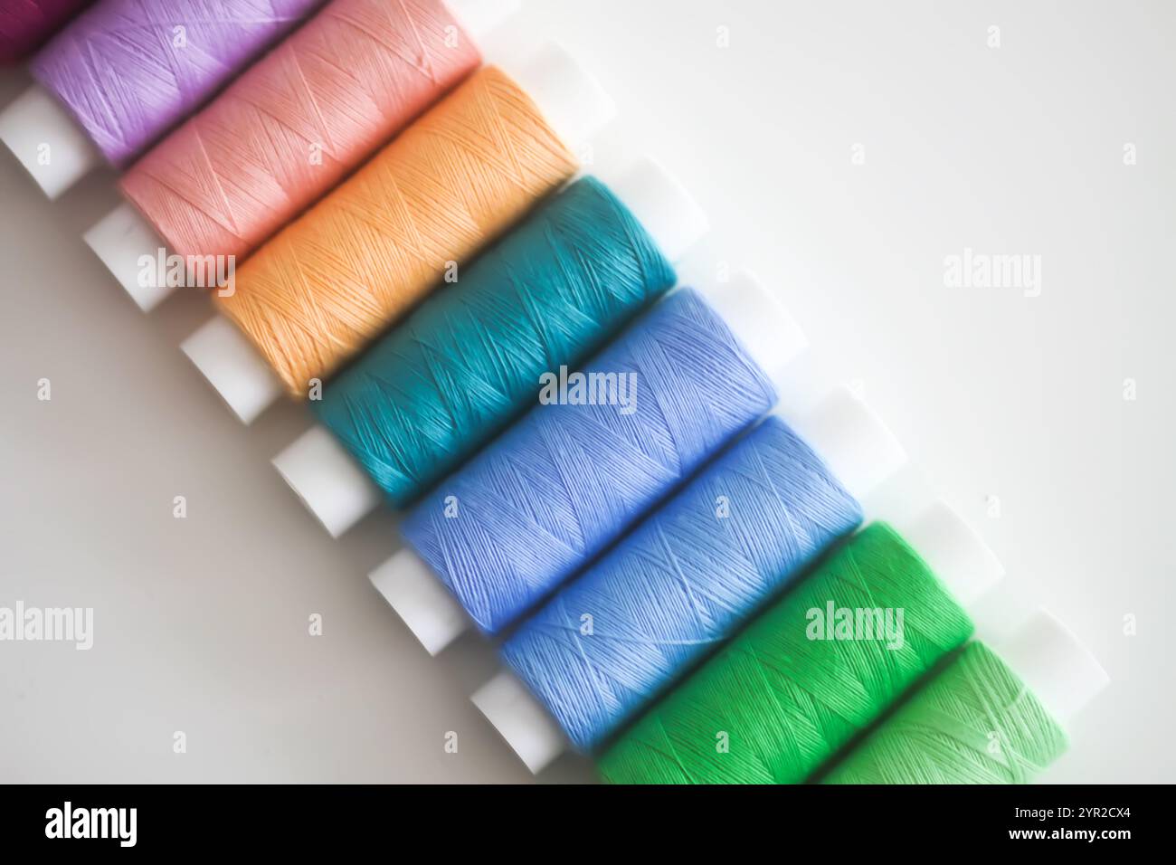 Many colorful sewing threads on light background. Stock Photo